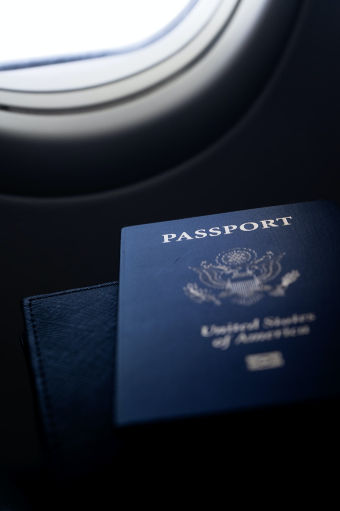 a passport placed next to an airplane window