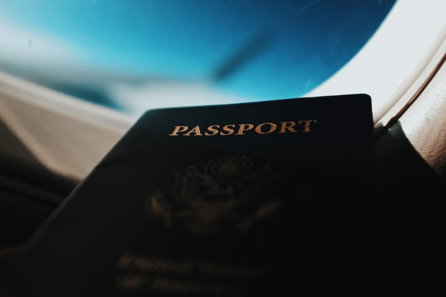 A passport near an airplane window