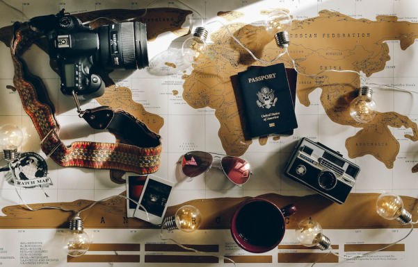 Passport, camera, and sunglasses on the world map 
