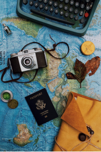 camera and passport lying on top of a map