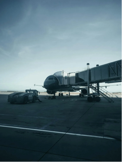 A photo showing an airplane parked at a gate.