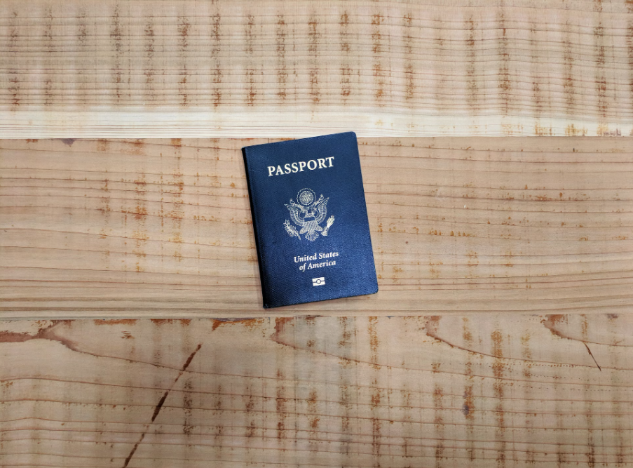 A passport on a wooden table.