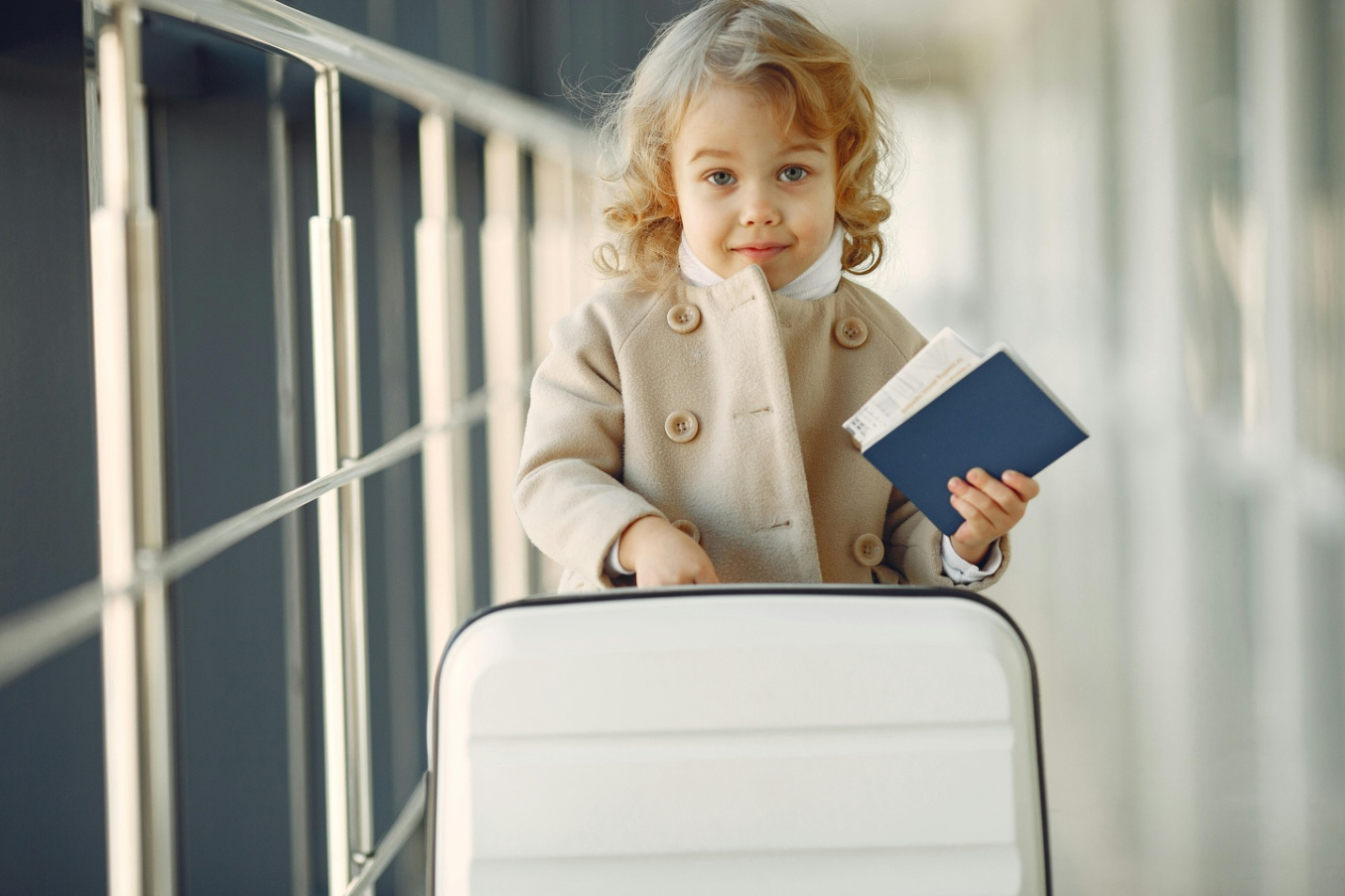 Little girl with a suitcase and passport in hand