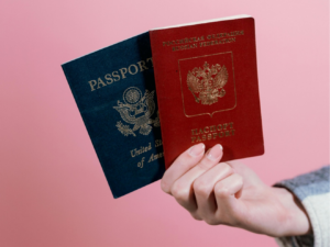 Cropped person holding two passports in hand