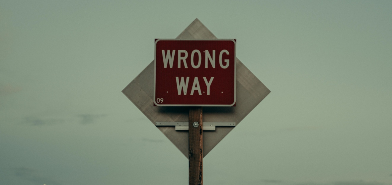A roadside directional sign demonstrating a wrong way