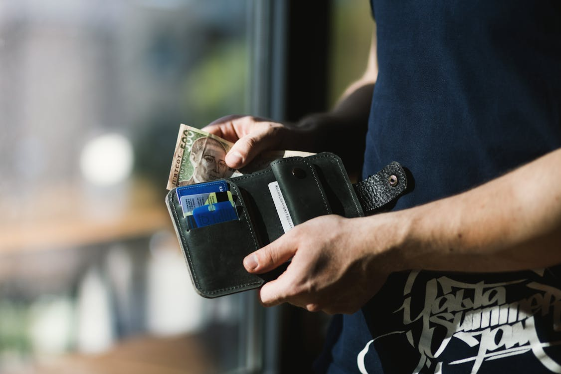A person keeping back money in their wallet