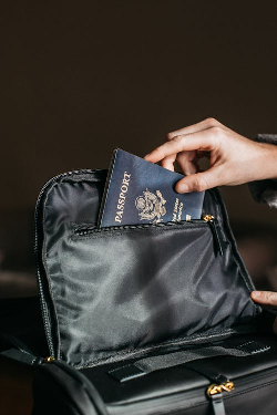 a person putting their passport in a bag